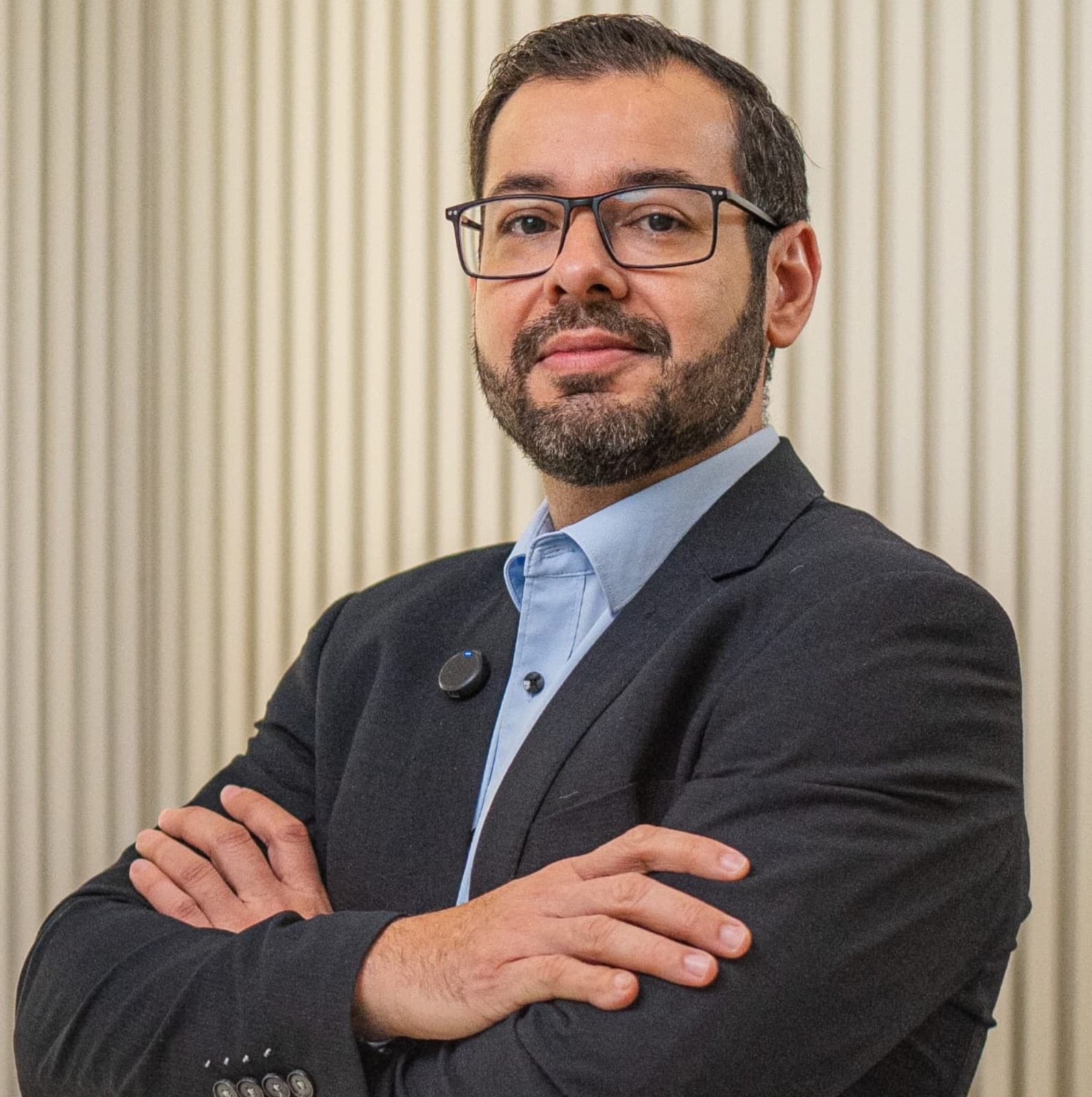 Doutor Clovis Fagundes Botelho, Graduado em Medicina pelo Centro Universitário de Várzea Grande, com especialização em Medicina Intensiva. Ele está sorrindo e usa camisa social com gravata. Ao redor do seu pescoço tem um aparelho de medir pressão dos pacientes.